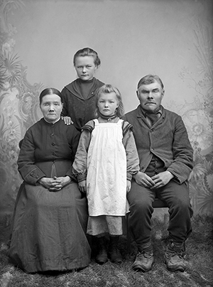 Ett foto av en familj från förra sekelskiftet. En äldre kvinna som ser ut att vara blind, en äldre man och två flickor, 8-12 år.