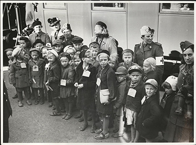Barn vid tågstation med lapp om halsen
