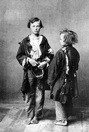 Två pojkar barfota och klädda i trasor
