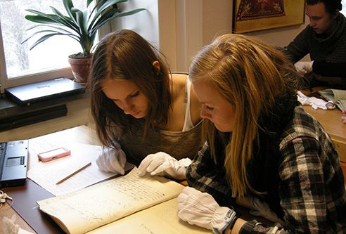 Elever som studerar arkivmaterial