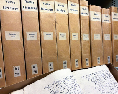 Arkivhyllor med domböcker från Västra häradsrätt och gamla handskrivna dokument.