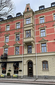 ett rött tegelhus med fyra våningar