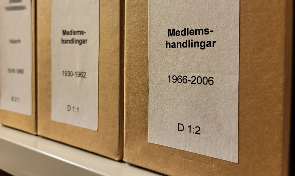 Lådor märkta ”Medlemshandlingar” med datum från 1930–1962 och 1966–2006, placerade på en hylla.