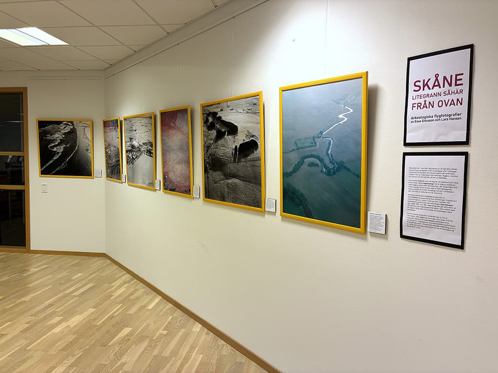 Utställning med flygfotografier på en vit vägg.