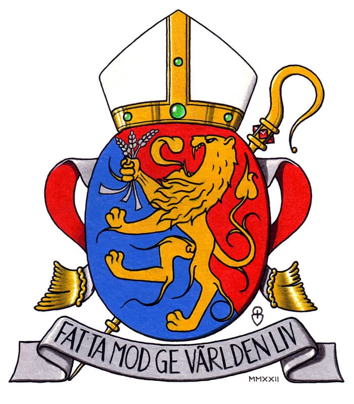 Vapensköld med biskopsmössa och kräkla (biskopsstav) ovanpå skölden. Skölden är uppdelad i fyra kvadranter, två med gyllene lejon på blå bakgrund och två med korsade nycklar på röd bakgrund, symboler kopplade till kristendom och makt. Under skölden finns ett band med texten 'FATTA MOD GE VÄRLDEN LIV.'