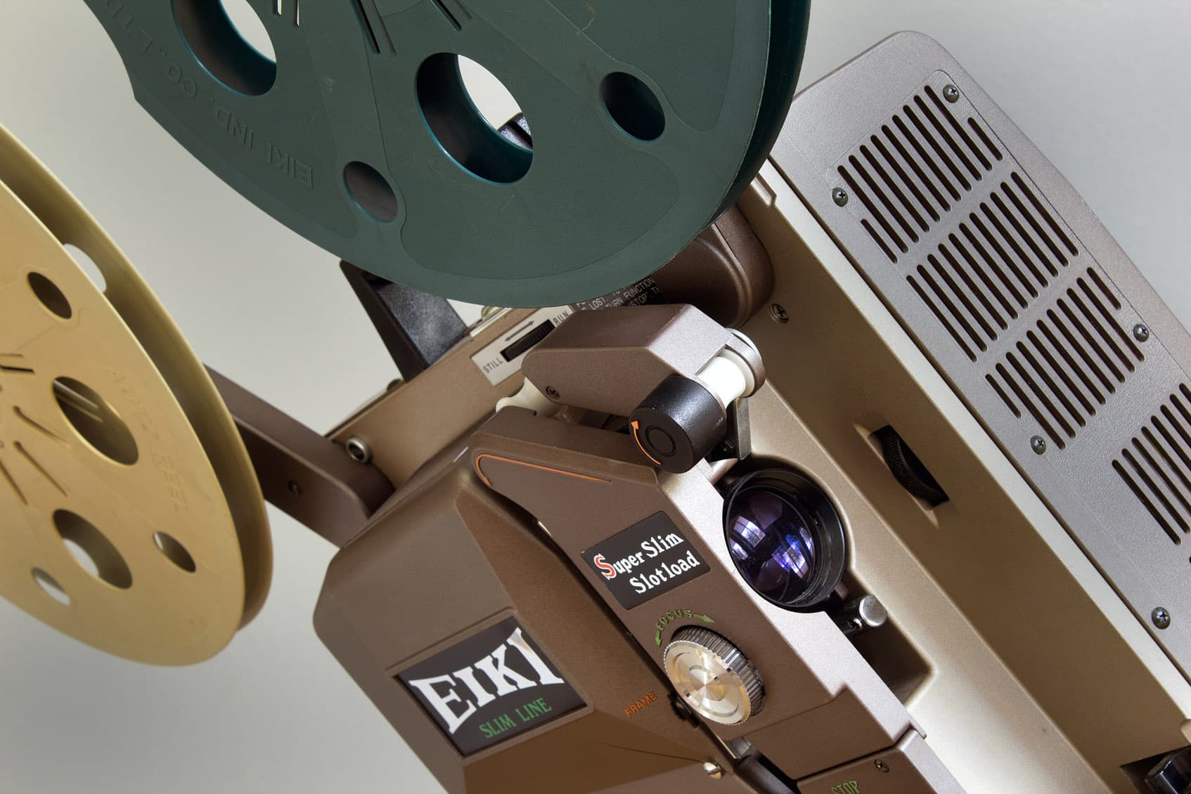 En närbild av en vintage filmprojektor med filmrullar monterade.