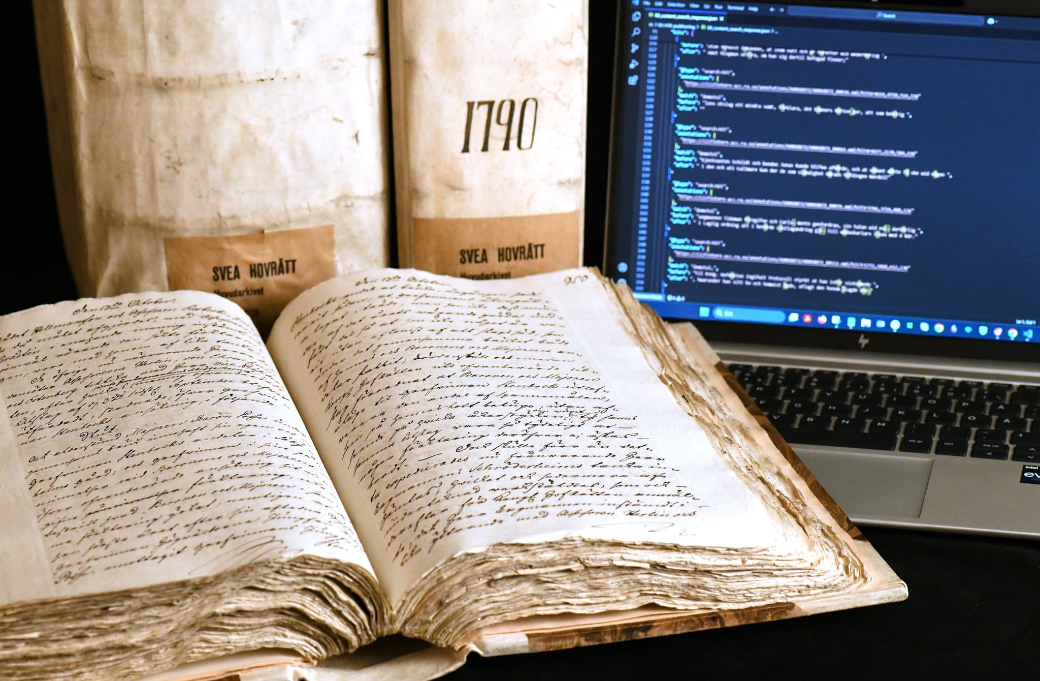 Volm uppslagen bredvid dator och flera andra stängda volymer.