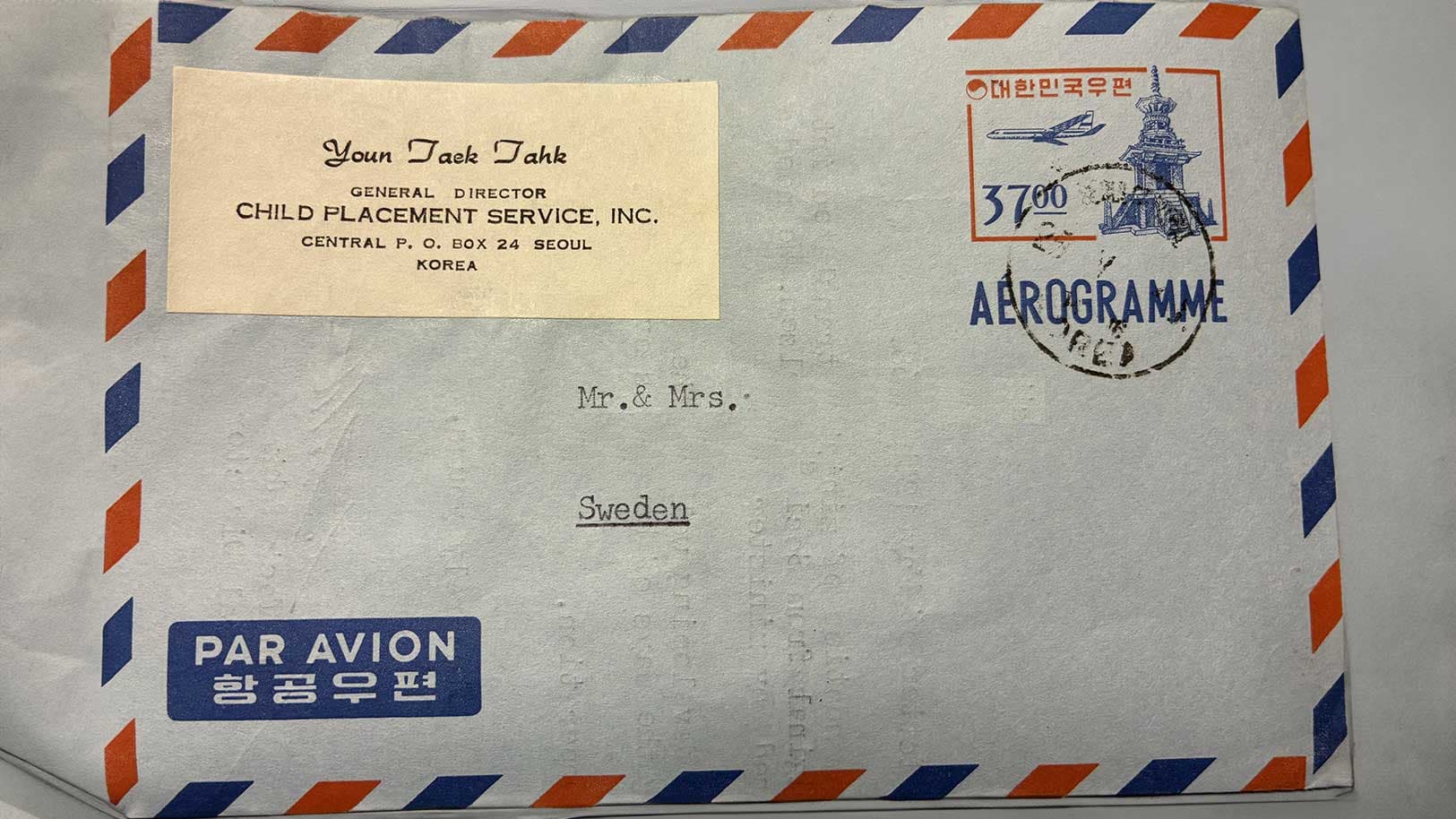 Flygpostbrev från Child Placement Service, Inc. i Seoul, Korea, adresserat till ett par i Sverige. Kuvertet har blå och röd kant samt texten "PAR AVION" och "AEROGRAMME". Avsändare är Youn Taek Tahk, General Director.