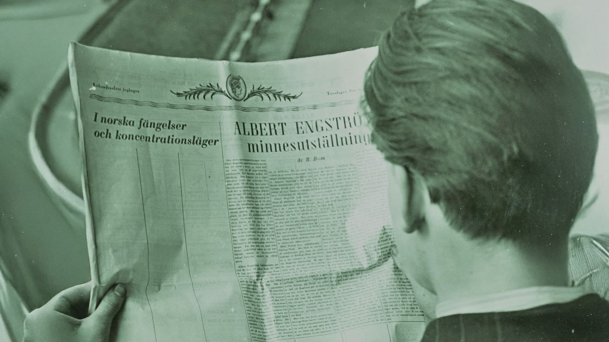 Person läser svensk tidning med rubriker om Albert Engström och norska fångläger.