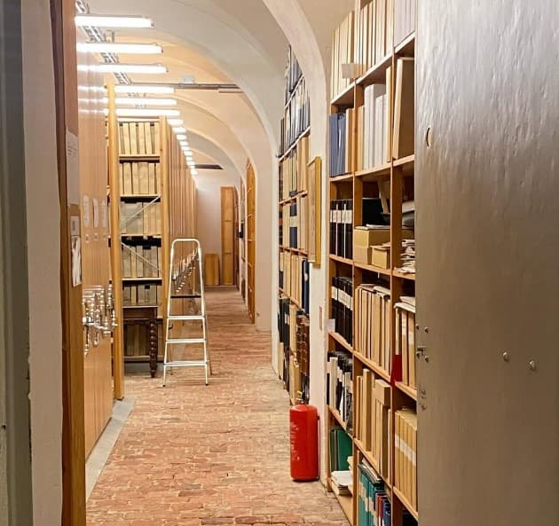 dörröppning in till gammal arkivlokal med tegelgolv.