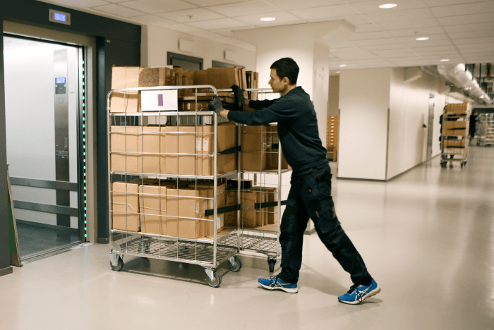 man som skjuter vagn med arkivhandlingar.