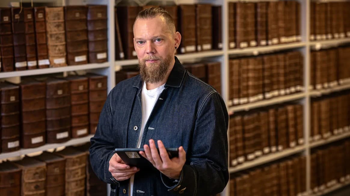 man framför hyllor med böcker