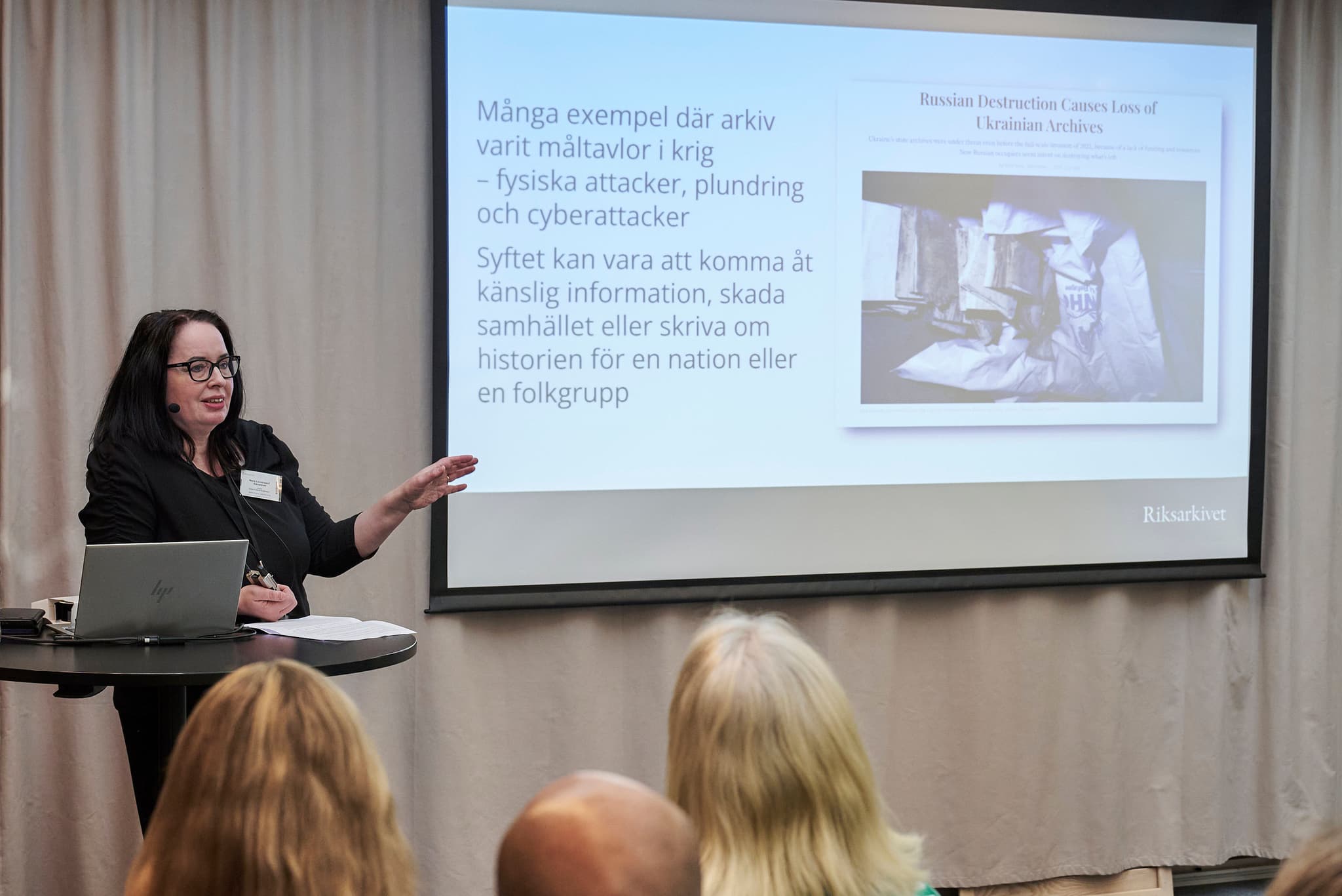 kvinna talar vid en PPT-presentation på storduk
