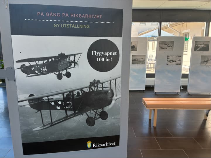 Affisch med ett svartvitt fotografi av två äldre flygplan och texten: "På gång på Riksarkivet. Ny utställning. Flygvapnet 100 år!".